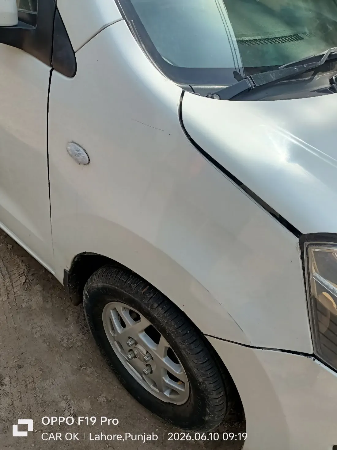 White hatchback front fender with paint damage and panel gaps found during doorstep car inspection in Lahore by CarOK