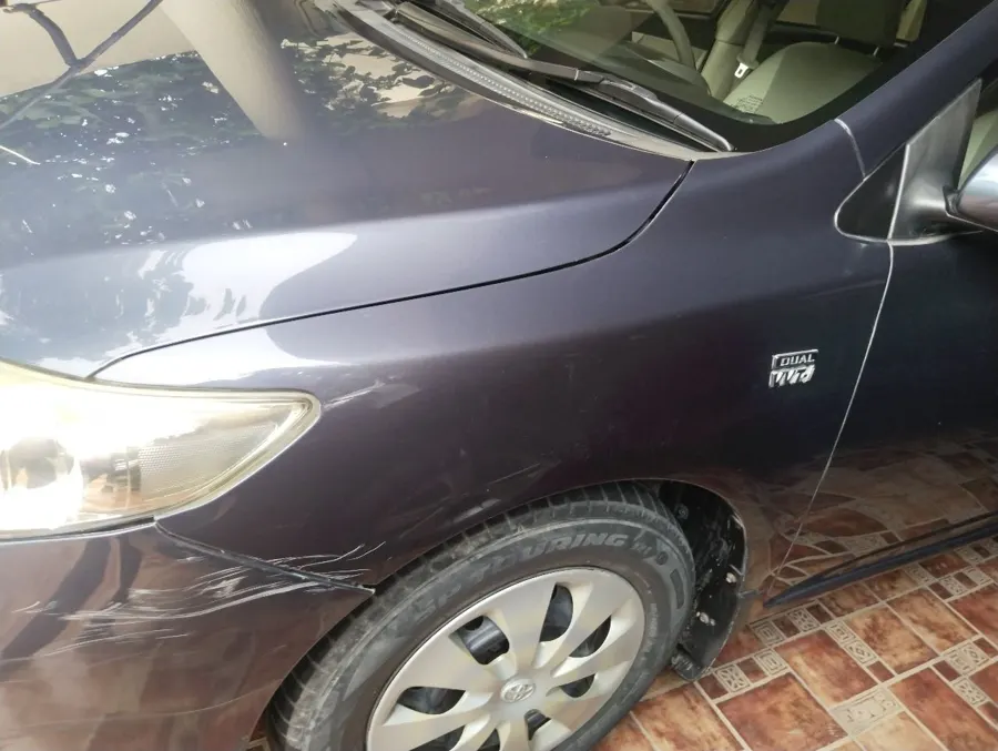 Scratches and scuffs on the front fender of the Corolla