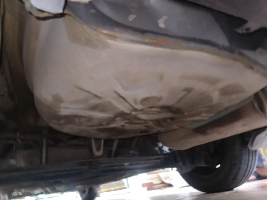 Underbody of the Corolla showing an impact mark on the floor pan